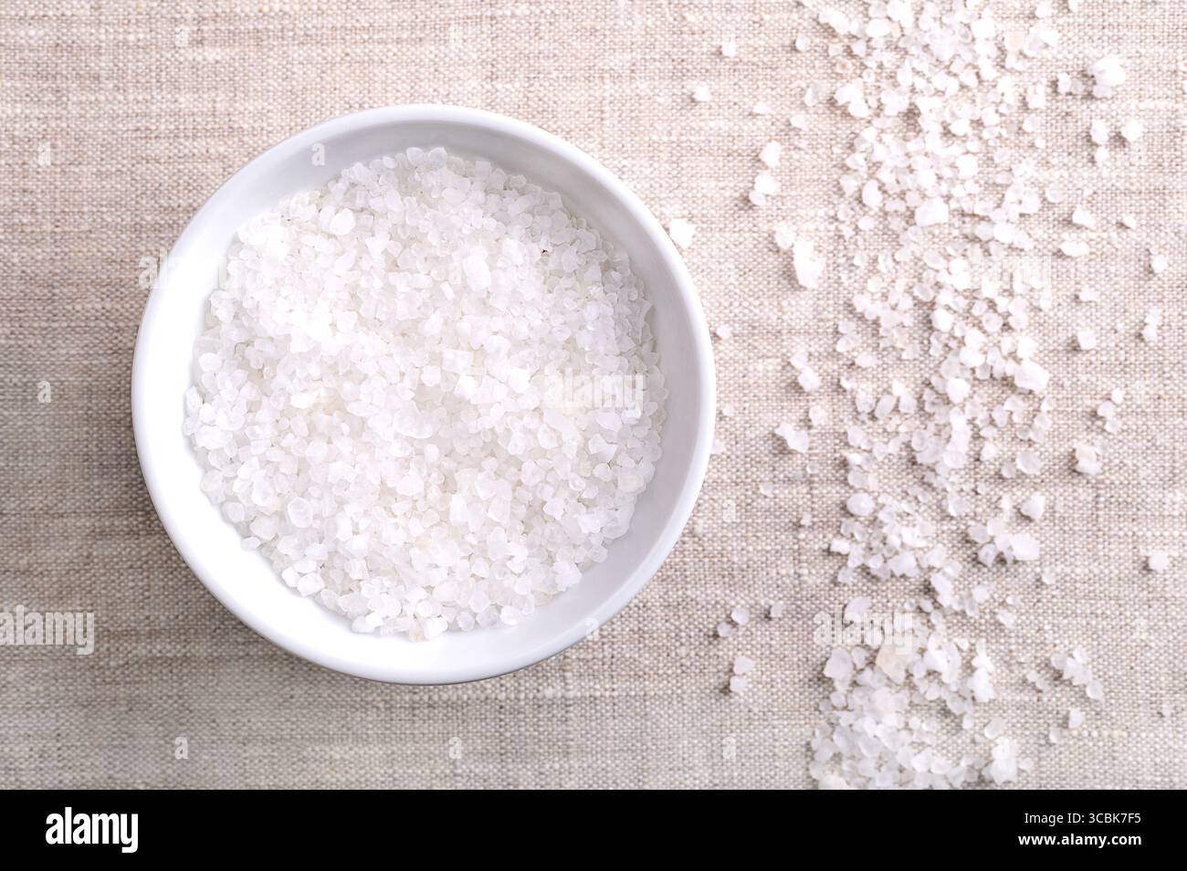 Salz aus dem Toten Meer in einer Holzschale auf Leinen. Grobes, kristallisiertes Salz aus dem Toten Meer. Reich an Chlorid, Magnesium, Natrium, Calcium und Kalium Stockfoto