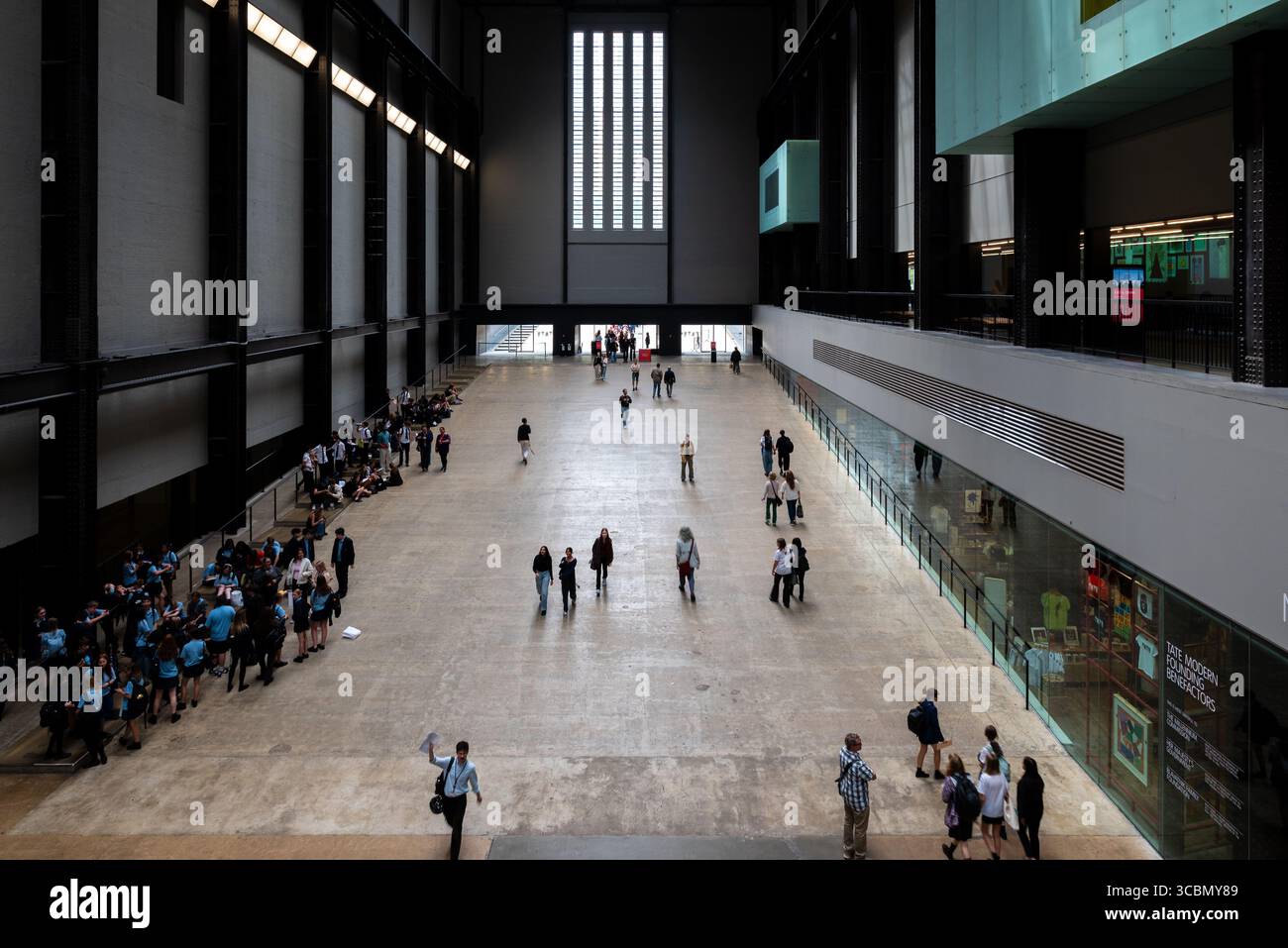 London, UK 04 August 2025 Silhouetten von Menschen gehen in das moderne Gebäude des ehemaligen Kraftwerks Bankside, Stockfoto
