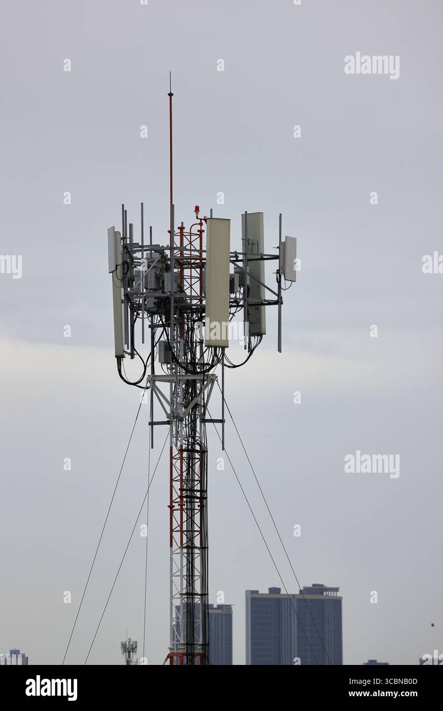 Antennenmast für drahtlose Kommunikation, Antennenmast für Mobiltelefone auf dem heruntergekommenen Gebäude. Stockfoto