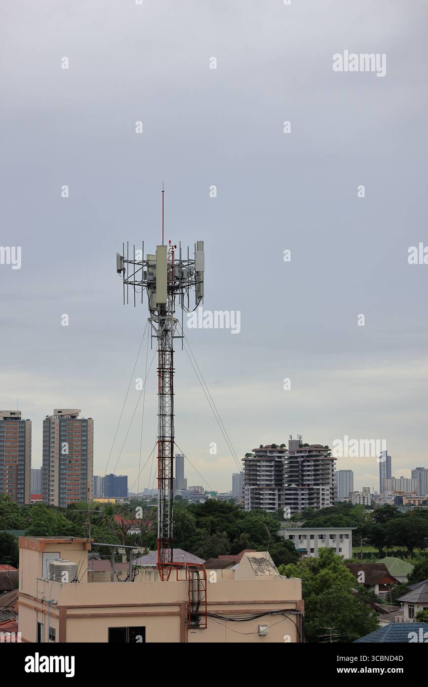 Antennenmast für drahtlose Kommunikation, Antennenmast für Mobiltelefone auf dem heruntergekommenen Gebäude. Stockfoto