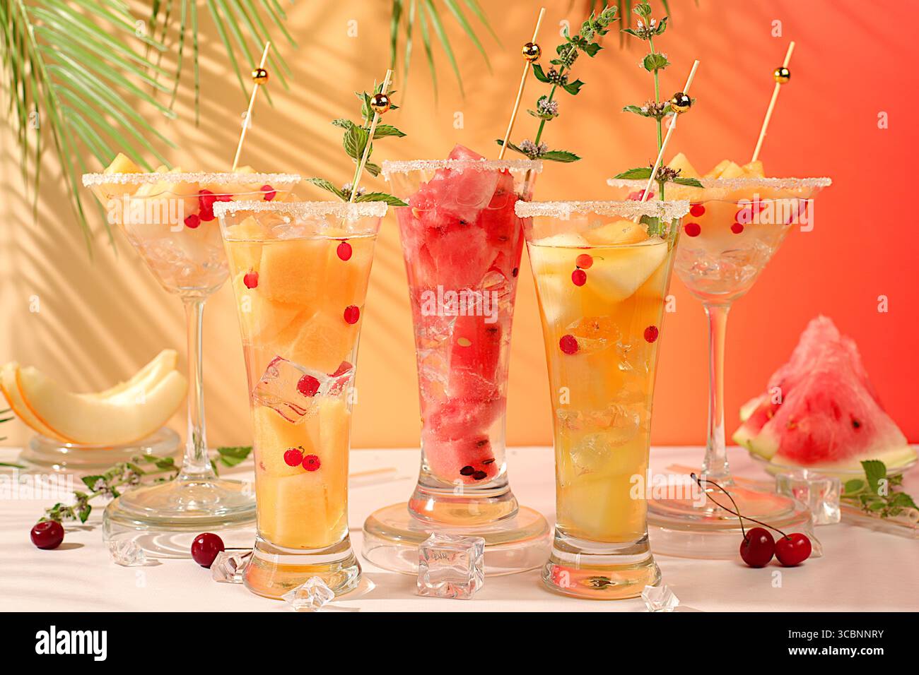 Sommerparty-Konzept, Bar- oder Café-Werbung. Alkoholischer Cocktail mit Melonen und Wassermelonen mit Minze. Martini und königliche Sangria mit Melonenscheiben, Eis, Stockfoto