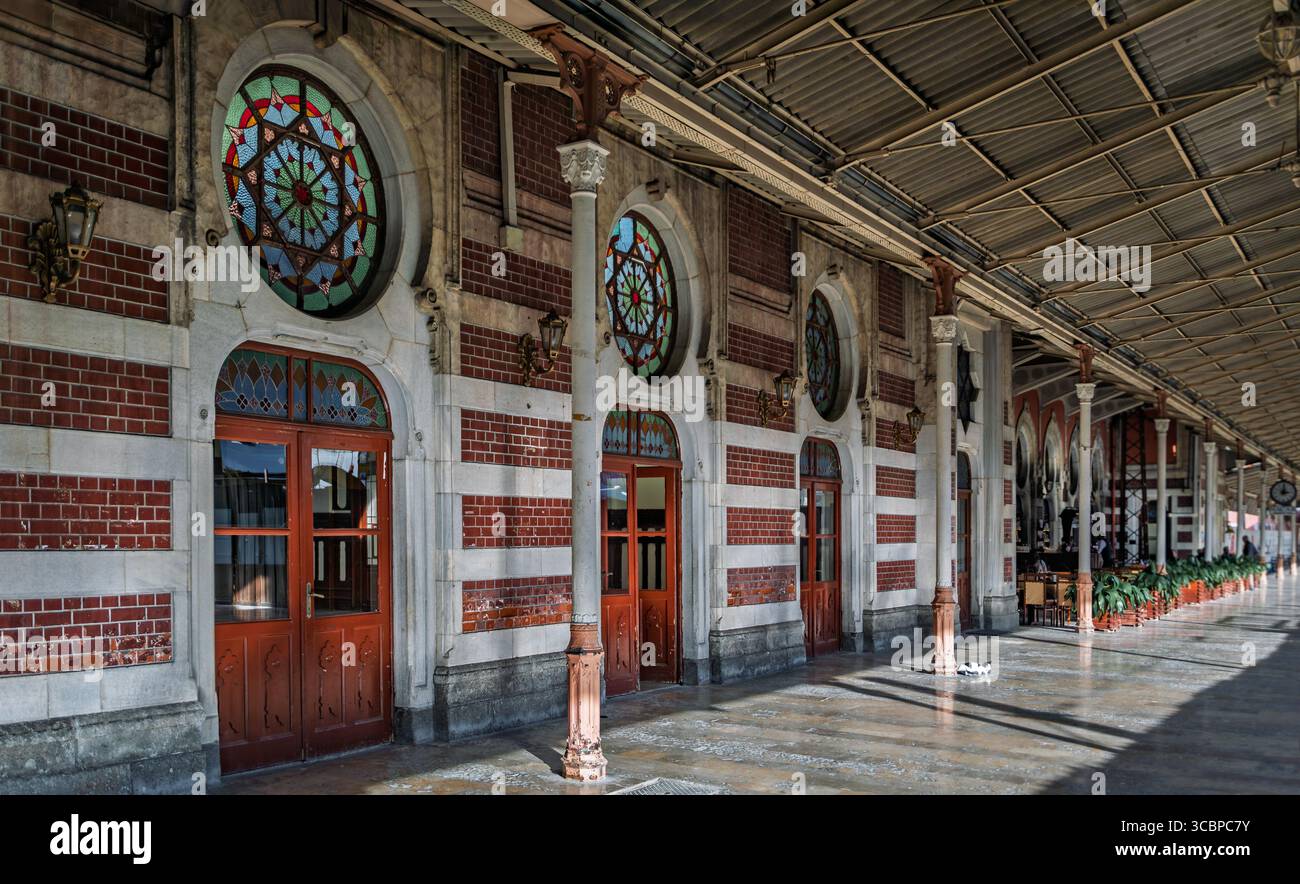 Istanbul, Türkei - 10. November 2023: Kunstvolle Fassade des historischen Sirkeci Terminals mit kontrastierenden Ziegelwänden und Buntglasfenstern mit Sternmuster Stockfoto