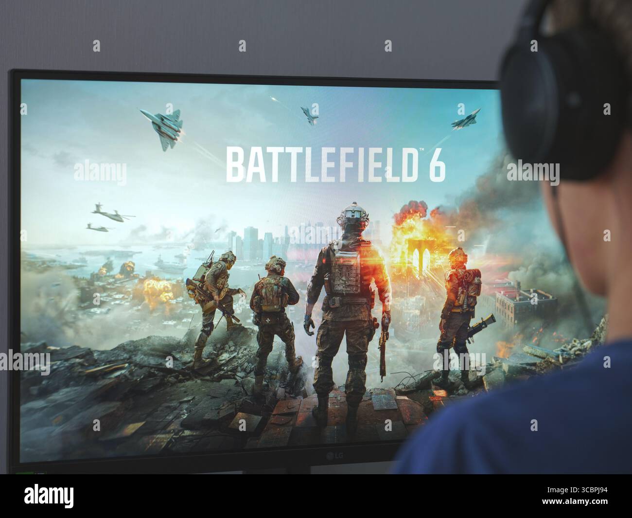 Tambow, Russische Föderation - 08. August 2025 Ein junger Mann sitzt hinter einem Computer, auf dem der Bildschirm zum Laden des Spiels Battlefield 6 steht. Stockfoto