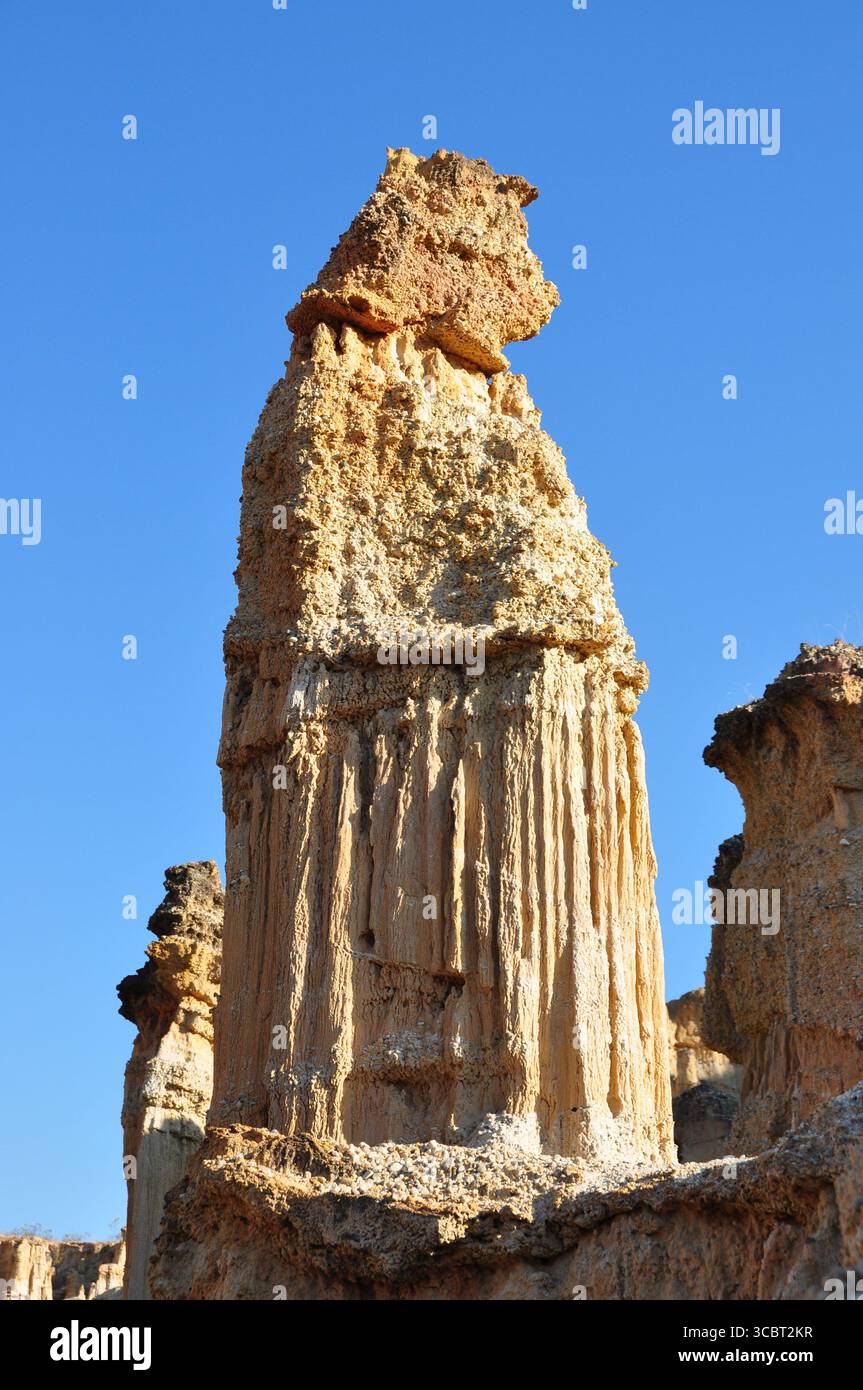 Erodierter SandsteinHoodoo erhebt sich vor einem klaren blauen Himmel im Yuanmou Earth Forest, Yunnan, China, und zeigt dramatische natürliche Felsformationen und -Texturen Stockfoto