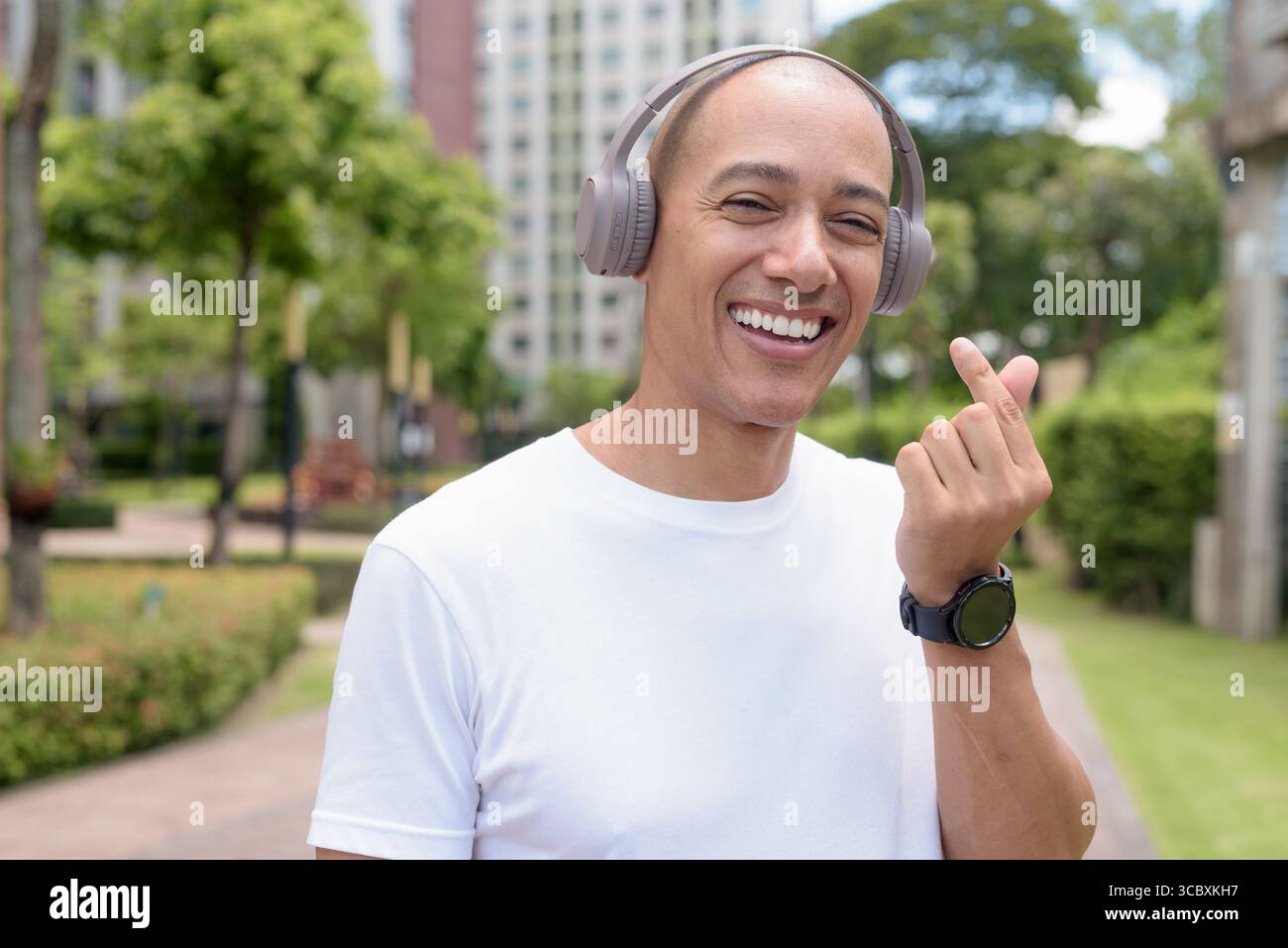 Glatze Latin man spaziert in der Stadt oder im Park und genießt die Bewegung im Freien. Fängt selbstbewussten Wellness-Lebensstil, aktive Gewohnheiten und gesunde Sommer Urban ein Stockfoto