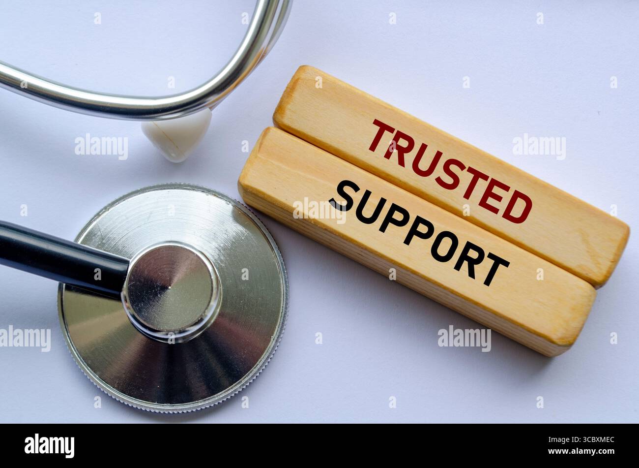 VERTRAUENSWÜRDIGER SUPPORT Text auf Holzblöcken neben einem Stethoskop, der vertrauenswürdige medizinische Unterstützung und zuverlässigen Service bietet, um Gesundheit und Kundenvertrauen zu gewährleisten Stockfoto