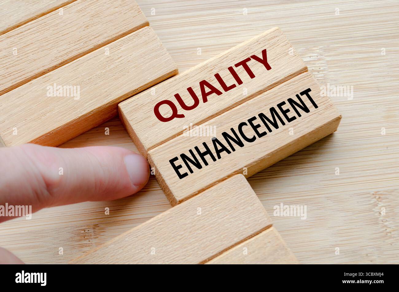 Text ZUR QUALITÄTSVERBESSERUNG auf Holzblöcken, umfassende Maßnahmen zur Qualitätsverbesserung, um Erwartungen zu übertreffen und die Markenqualität zu erhalten. Stockfoto