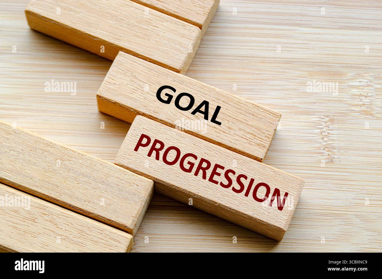 Text ZUM ZIELFORTSCHRITT auf Holzblöcken, Schritten und Strategien, um einen konsistenten und messbaren Zielfortschritt im Zeitverlauf zu gewährleisten. Stockfoto