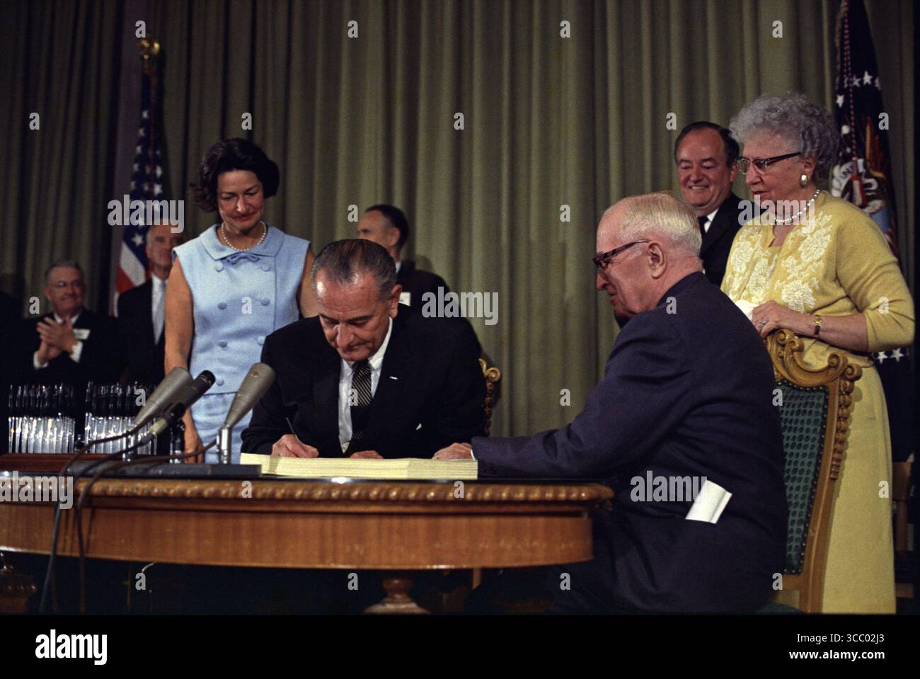 12 32 weitere Details Präsident Lyndon B. Johnson unterzeichnete das Medicare Bill in der Harry S. Truman Library in Independence, Missouri. Der ehemalige Präsident Harry S. Truman sitzt mit Präsident Johnson am Tisch. Stockfoto