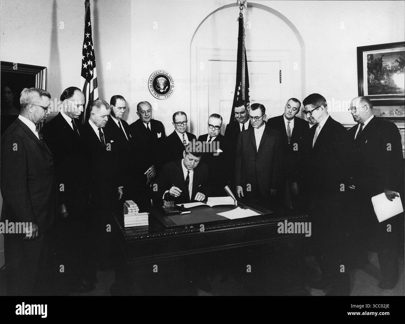 Präsident John F. Kennedy unterschreibt am 20. Mai 1963 im Oval-Büro des Weißen Hauses die Futterkörner Bill. (L bis R Assistant Secretary of Agriculture John P. Duncan Jr., Texas Representative Graham Purcell, Texas Representative W. H. Poage, South Carolina Senator Olin D. Johnston, North Carolina Representative Harold D. Cooley, Louisiana Senator Allen Ellender, Missouri Representative Paul C. Jones, National Farmers Organization Representative Oran Staley, National Farmers Union Representative Glen Talbott, Agricultural Stabilization and Conservation Service (ASCS) Agriculture Department eDWI Stockfoto