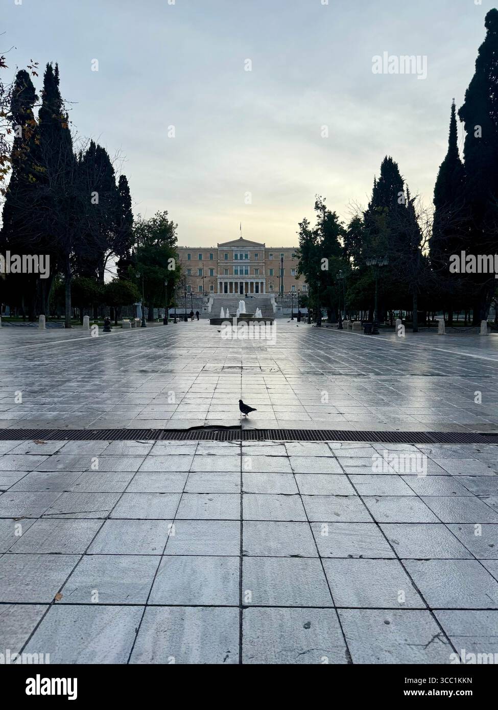 Blick auf den Syntagma-Platz bei Sonnenuntergang in Athen, Griechenland, mit dem Parlamentsgebäude im Hintergrund. Stockfoto