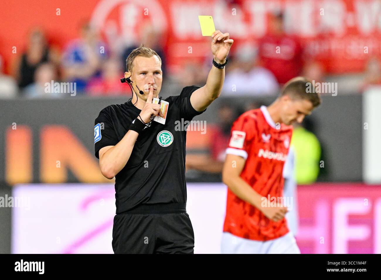 Kaiserslautern, Deutschland. August 2025. Fußball: Bundesliga 2, 1. FC Kaiserslautern - FC Schalke 04, Spieltag 2, Fritz-Walter-Stadion. Schiedsrichter Martin Petersen zeigt die gelbe Karte. Hinweis: Uwe Anspach/dpa - WICHTIGER HINWEIS: Gemäß den Vorschriften der DFL Deutschen Fußball-Liga und des DFB Deutschen Fußball-Bundes ist es verboten, im Stadion und/oder des Spiels aufgenommene Fotografien in Form von sequenziellen Bildern und/oder videoähnlichen Fotoserien zu verwenden oder zu verwenden./dpa/Alamy Live News Stockfoto