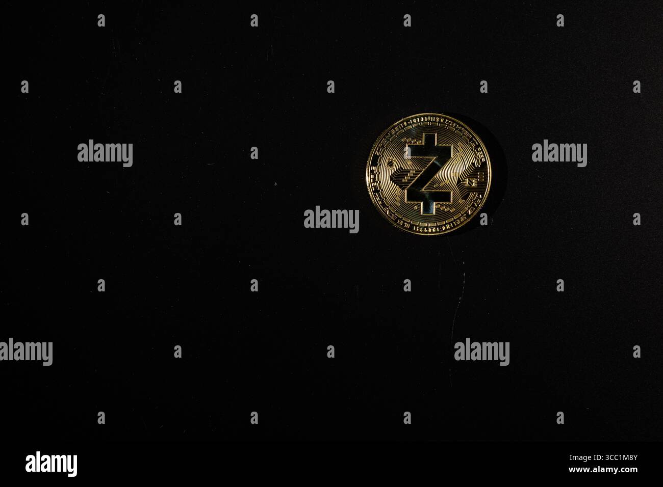 Eine Nahaufnahme einer goldenen Kryptowährungsmünze auf einer schwarzen Oberfläche, die ihre komplizierten Details zeigt und digitale Währung und Blockchain repräsentiert Stockfoto