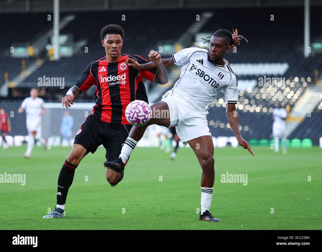 Craven Cottage, Fulham, London, Großbritannien. August 2025. Fussballfreundlich vor der Saison, Fulham gegen Eintracht Frankfurt; Alex Iwobi von Fulham, herausgefordert von Nnamdi Collins von Eintracht Frankfurt Credit: Action Plus Sports/Alamy Live News Stockfoto