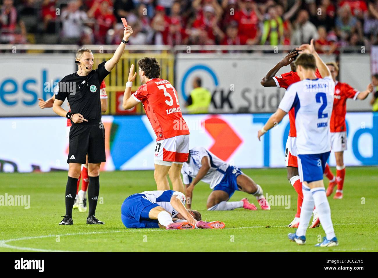 Kaiserslautern, Deutschland. August 2025. Fußball: Bundesliga 2, 1. FC Kaiserslautern - FC Schalke 04, Spieltag 2, Fritz-Walter-Stadion. Schiedsrichter Martin Petersen zeigt Leon Robinson (1. FC Kaiserslautern) die rote Karte. Die Entscheidung wurde später rückgängig gemacht. Hinweis: Uwe Anspach/dpa - WICHTIGER HINWEIS: Gemäß den Vorschriften der DFL Deutschen Fußball-Liga und des DFB Deutschen Fußball-Bundes ist es verboten, im Stadion und/oder des Spiels aufgenommene Fotografien in Form von sequenziellen Bildern und/oder videoähnlichen Fotoserien zu verwenden oder zu verwenden./dpa/Alamy Live News Stockfoto