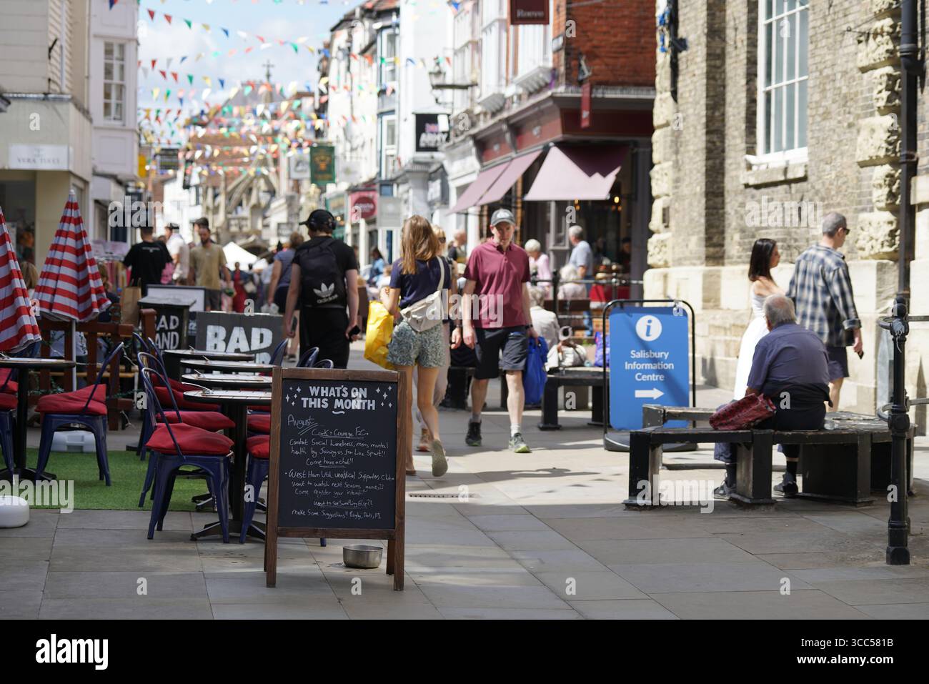 Belebte Fußgängerzone mit Geschäften, Cafés im Freien und farbenfroher Dekoration. Salisbury, England Stockfoto