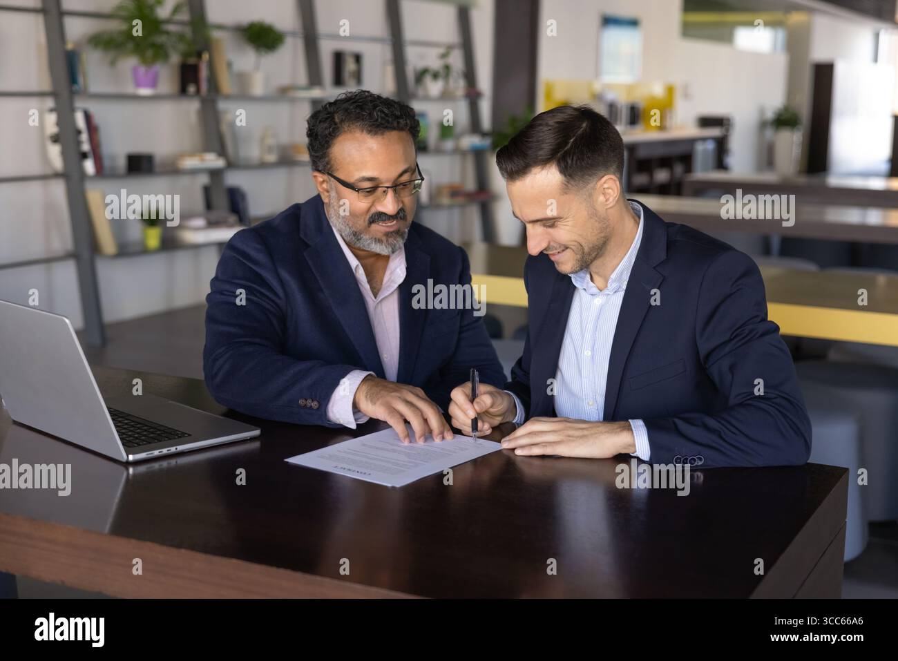 Reifer indischer Finanzexperte hilft jüngeren Partnern Stockfoto