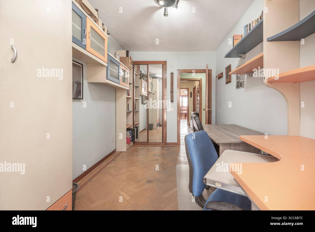 Helles Schlafzimmer mit weißem schwebenden Kleiderschrank und offenen Regalen für einen luftigen, übersichtlichen Look Stockfoto