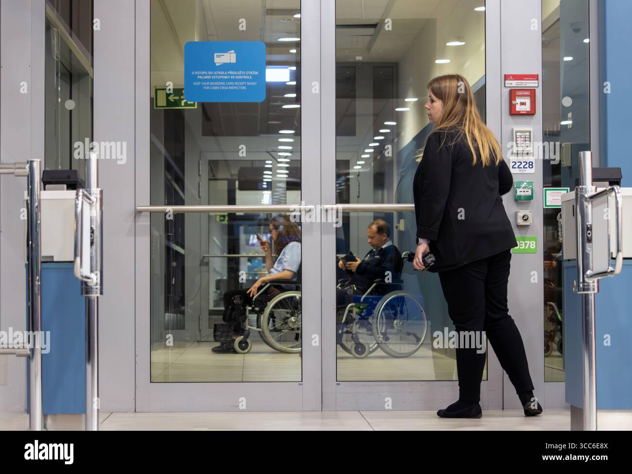 PRAG, TSCHECHIEN, 03. JULI 2025, Flughafenpersonal an der Tür zum Flur mit Rollstuhlfahrern Stockfoto
