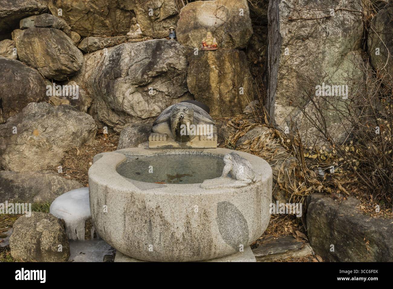 Yeongi-Gun, Südkorea. 24. Dezember 2020: Schildkrötenbrunnen, der in eine aus Stein gehauene Zisterne vor einer Felswand mündet Stockfoto Yeongi-Gun, Südkorea. 24. Dezember 2020: Schildkrötenbrunnen, der in eine aus Stein gehauene Zisterne vor einer Felswand mündet Stockfoto