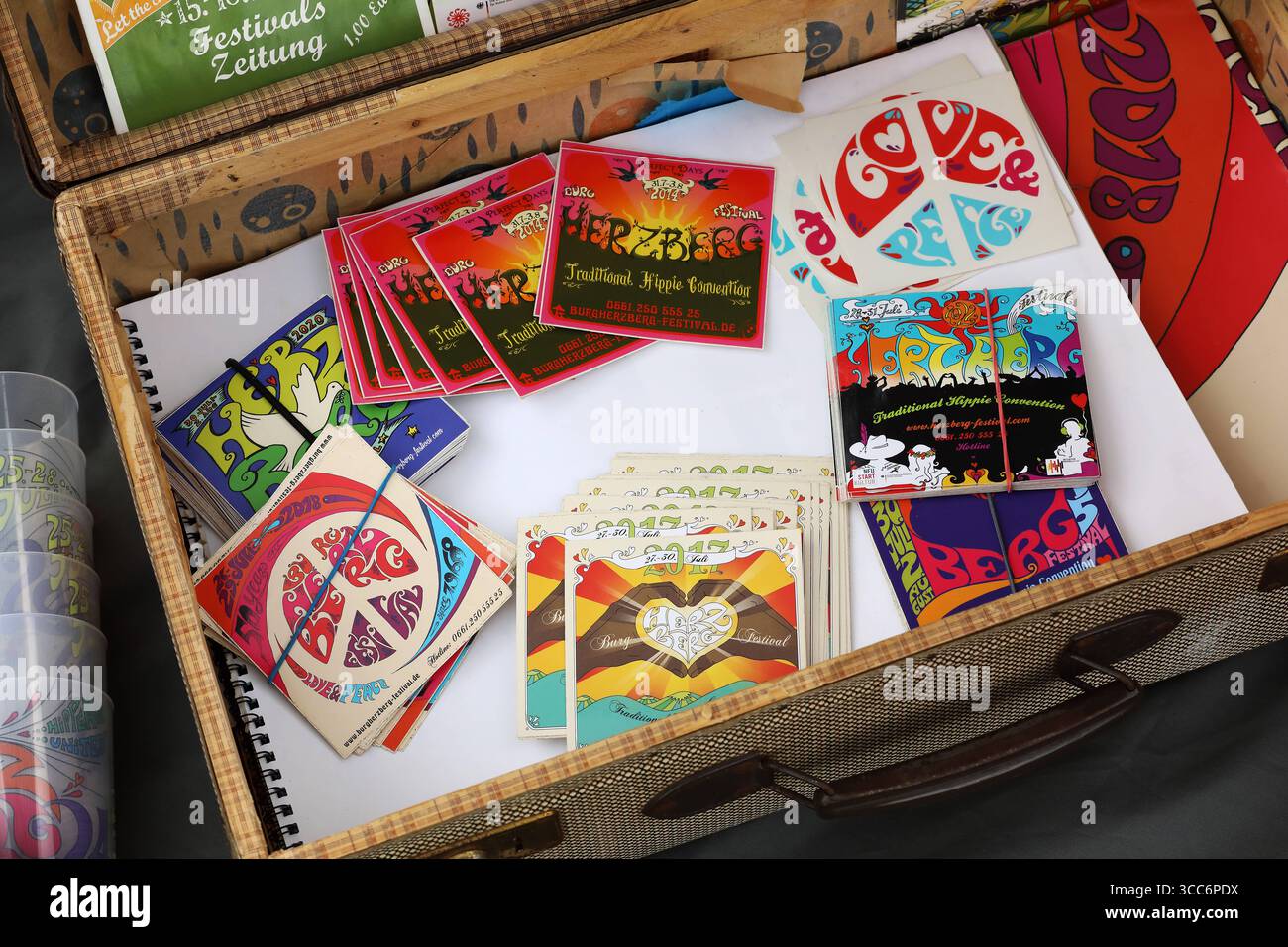 HERZBERG FESTIVAL 2025 - 24.07.2025, Breitenbach am Herzberg, Deutschland, Deutschland - das Herzberg Festival feiert in diesem Jahr seinen 55. Geburtstag unter dem Motto BERG VOLLER LIEBE C ãBerg voller LiebeÒ - wie in den vielen Jahren zuvor trifft sich hier die Hippie-Szene vom 24. bis 27. Juli in der Nähe der osthessischen Gemeinde Breitenbach am Herzberg, um auf der großen Festivalwiese Musik zu hören, zu tanzen und ausgelassen zu feiern. Zahlreiche Traktoren und Lkws mit ihren großen Wassertanks versorgt die Festival-Gemeinde. Angebot von Herzbergkalendern, Herzberg-Bechern und Herzberg-Fly Stockfoto