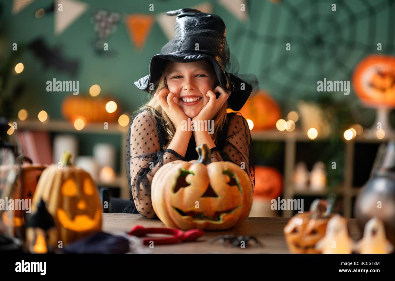 Mädchen im Hexenkostüm feiert Halloween. Kind mit Kürbissen Stockfoto