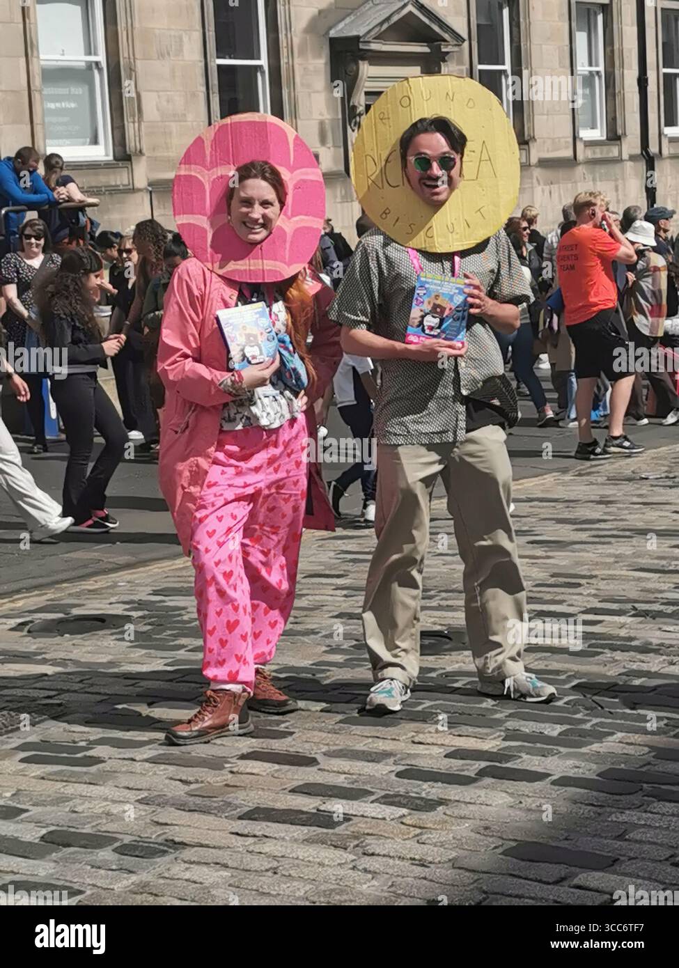 Straßenszenen und Acts verteilen Flyer für ihre Shows auf der Royal Mile in Edinburgh während des weltberühmten Edinburgh Fringe Festivals. - Smartphone-aufgenommenes Stockfoto