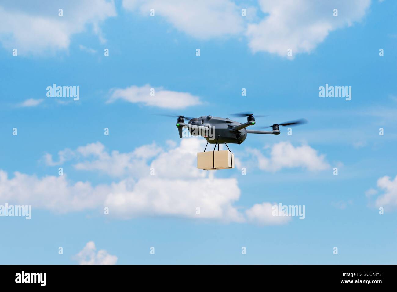 Lieferdrohne fliegt durch den blauen Himmel mit Papppaket für den Lufttransport Stockfoto