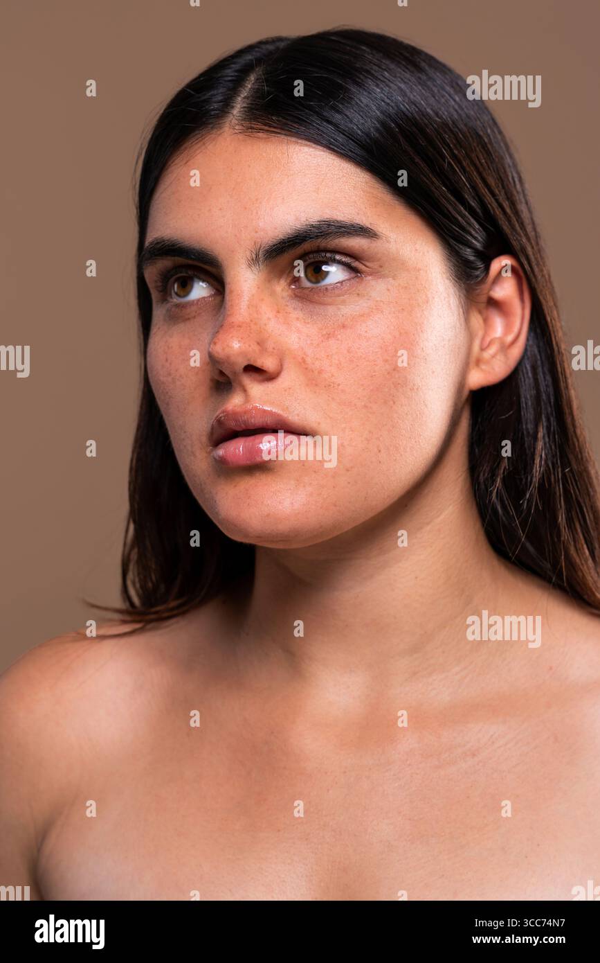 Nahaufnahme einer jungen Frau mit klarer Haut, die natürliche Schönheit und Hautpflegekonzepte in einem Studio präsentiert. Betonung auf Gesichtsmerkmale und Gesundheit Stockfoto