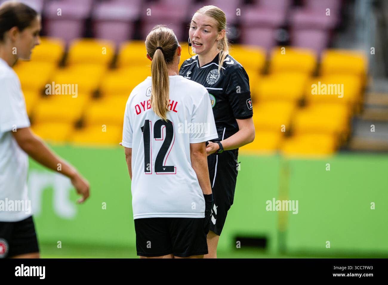 Farum, Dänemark. August 2025. Schiedsrichter Rie Louise Rasmussen sah mit Rikke Dybdahl (12) vom FC Midtjylland während des A-Liga-Spiels zwischen dem FC Nordsjaelland und dem FC Midtjylland rechts zum Dream Park in Farum. Quelle: Gonzales Photo/Alamy Live News Stockfoto