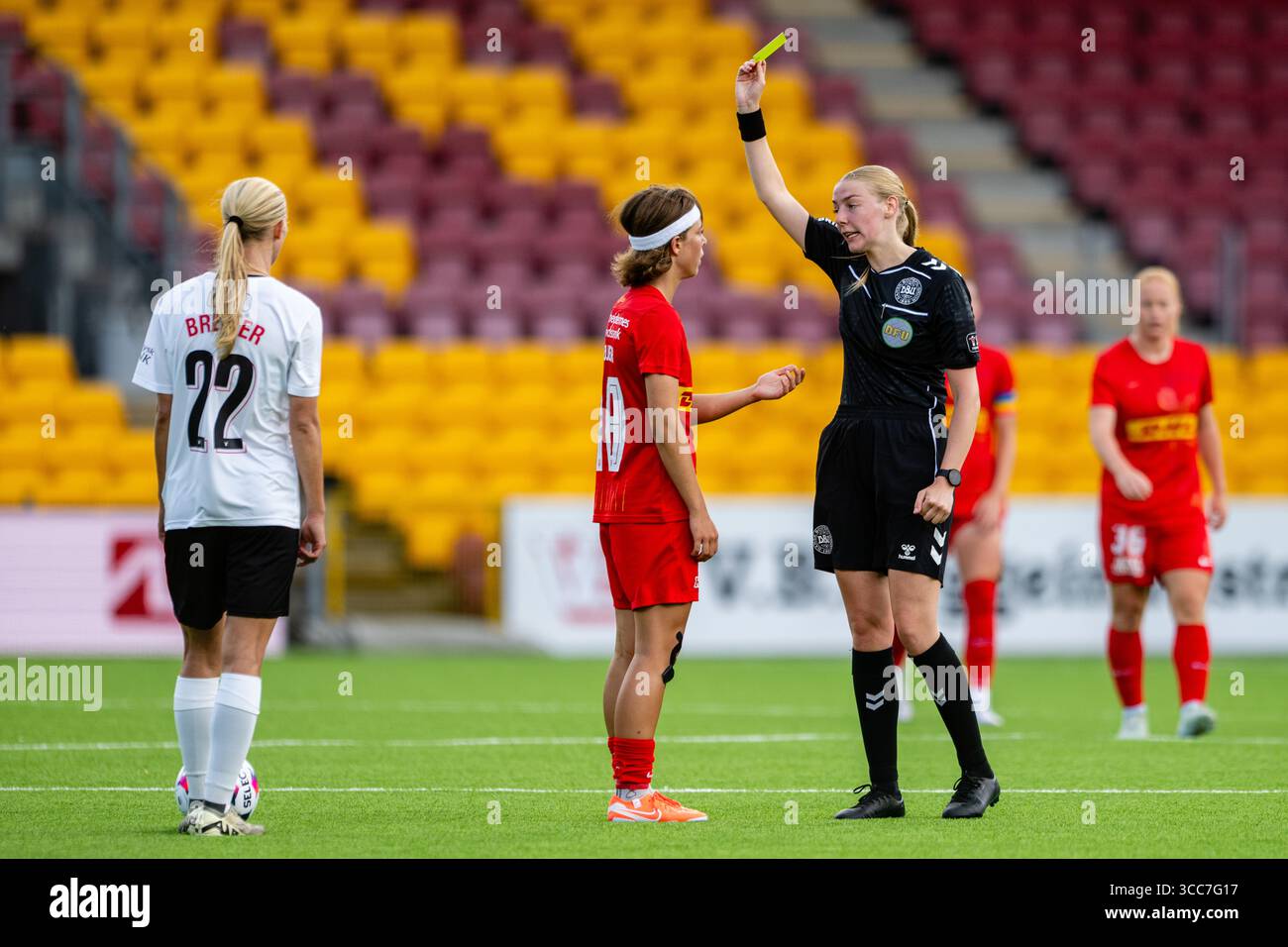 Farum, Dänemark. August 2025. Schiedsrichter Rie Louise Rasmussen führt Flora Hojer (18) vom FC Nordsjaelland während des A-Liga-Spiels zwischen dem FC Nordsjaelland und dem FC Midtjylland auf der rechten Seite zum Dream Park in Farum. Quelle: Gonzales Photo/Alamy Live News Stockfoto