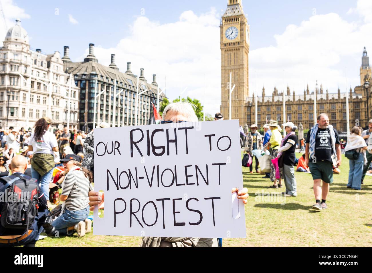 London, Großbritannien. AUGUST 2025. Lady hält das Schild „Unser Recht auf gewaltfreien Protest“, als die Polizei 466 Verhaftungen für Menschen vornahm, die Unterstützung für die neu verbotene Terrorgruppe Palestine Action zeigten. Bei der Aktion, die von der Verteidigung unserer Jurys organisiert wurde, wurden Menschen verhaftet, weil sie Plakate mit der Aufschrift "Ich bin gegen den Völkermord, ich unterstütze die Palästinensische Aktion" hielten. Sie fand auf dem Parlamentsplatz mit einer extrem starken Polizeipräsenz statt. Credit Milo Chandler/Alamy Live News Stockfoto