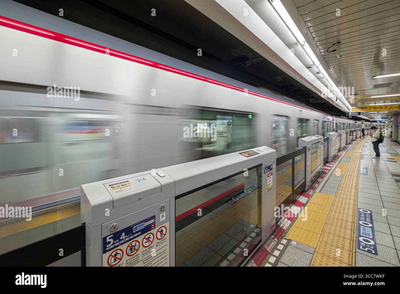 Tokyo Metro Hibiya Line Zug, der am Bahnsteig in der U-Bahn-Station Roppongi vorbeifährt, Minato City, Tokio, Kantō, Honshu, Japan Stockfoto