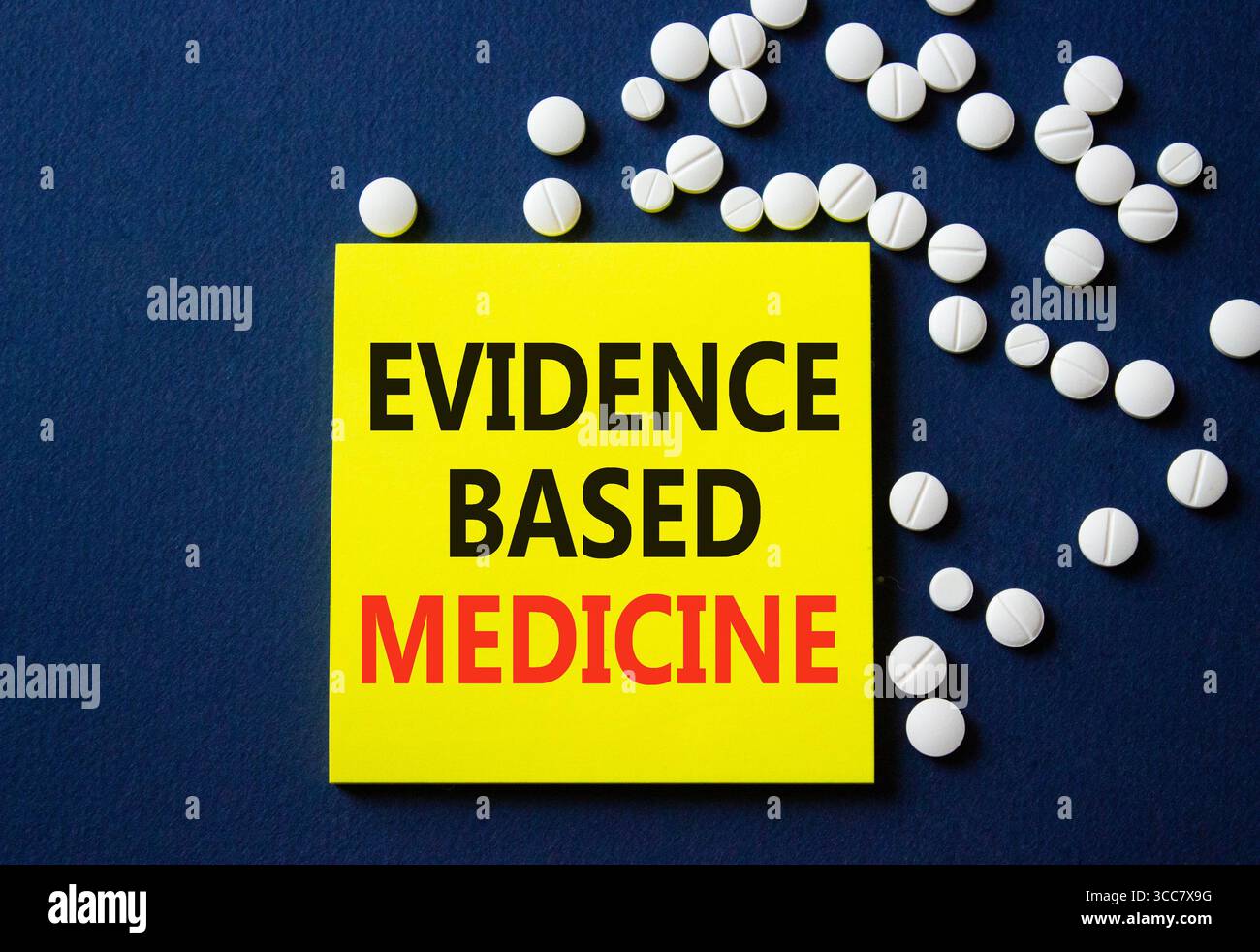 Evidence Based Medicine Symbol. Konzeptwort Evidenzbasierte Medizin auf gelber Note. Wunderschöner tiefblauer Hintergrund mit Pillen. Medizin und Evidenz Stockfoto