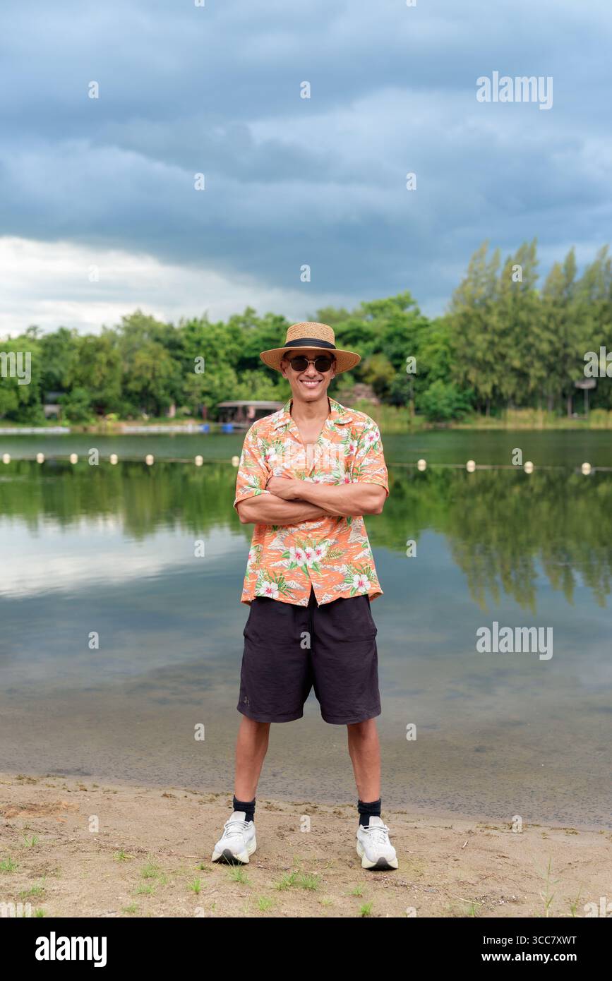 Hispanischer Mann mit Panamahut und hawaiianischem Hemd, gekleidet im lässigen Sommerurlaub-Stil. Er posiert am Strand und zeigt eine entspannte Urlaubsatmosphäre Stockfoto Hispanischer Mann mit Panamahut und hawaiianischem Hemd, gekleidet im lässigen Sommerurlaub-Stil. Er posiert am Strand und zeigt eine entspannte Urlaubsatmosphäre Stockfoto