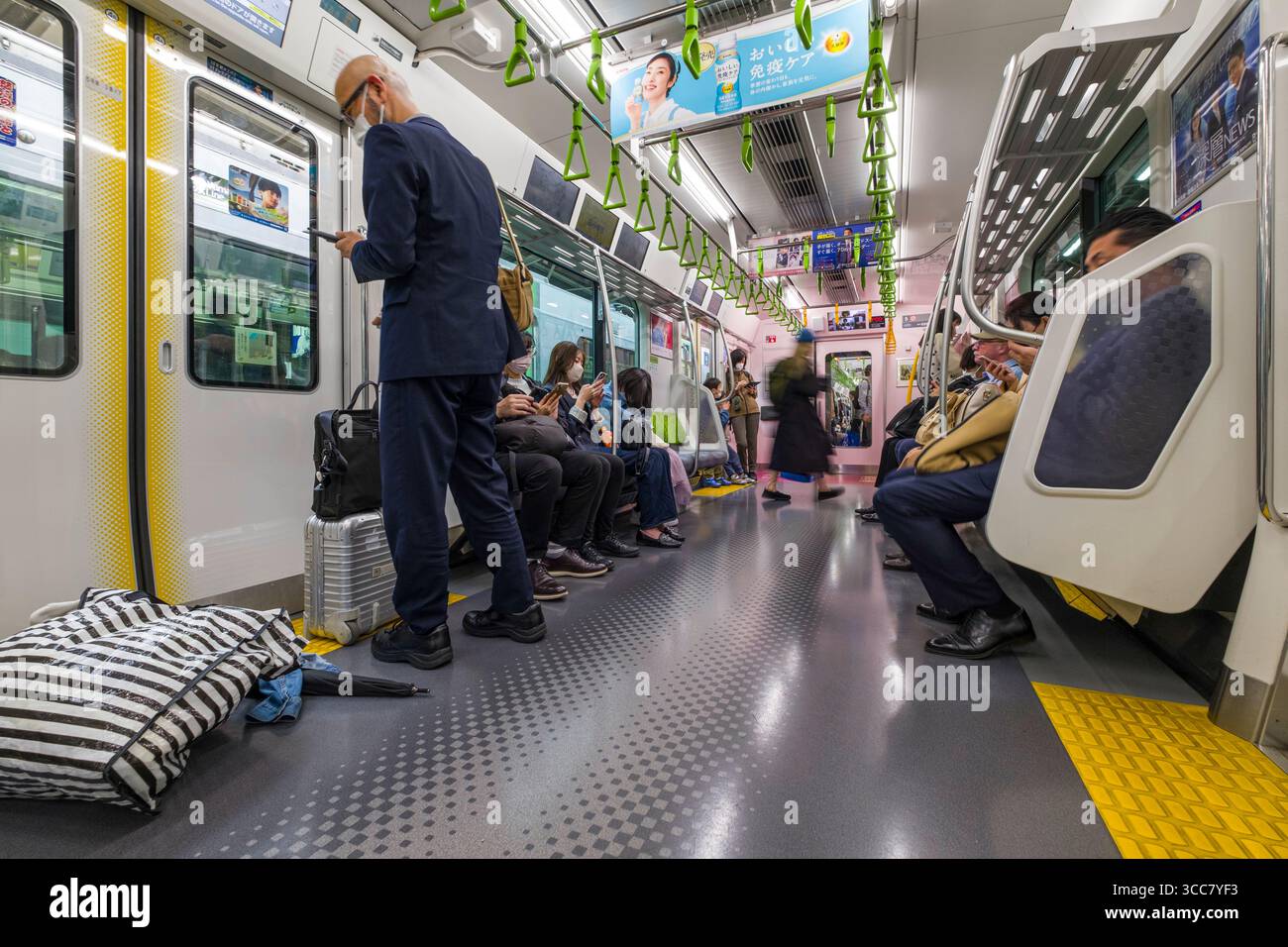 Passagiere, die in einem Zug der Yamanote-Linie sitzen, Tokio, Kantō, Honshu, Japan Stockfoto