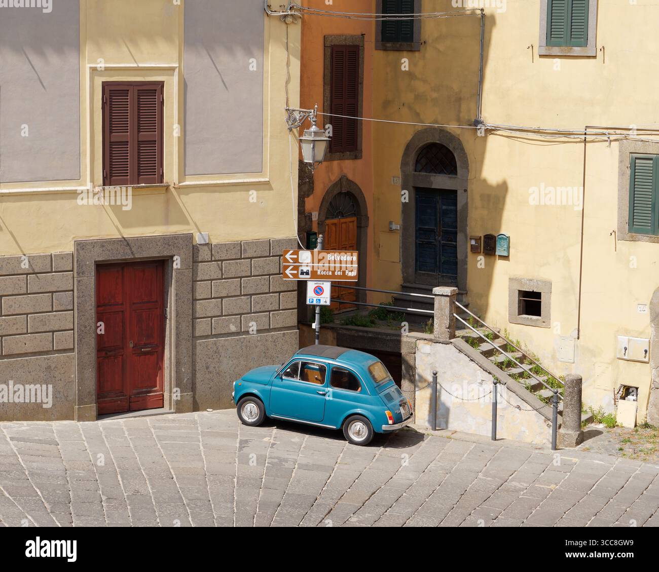 Klassischer Fiat 500 Wagen in Blau, geparkt an einem sonnigen Tag mit starkem Schatten in Montefiascone, Region Latium, Italien. Juni 2025. Stockfoto