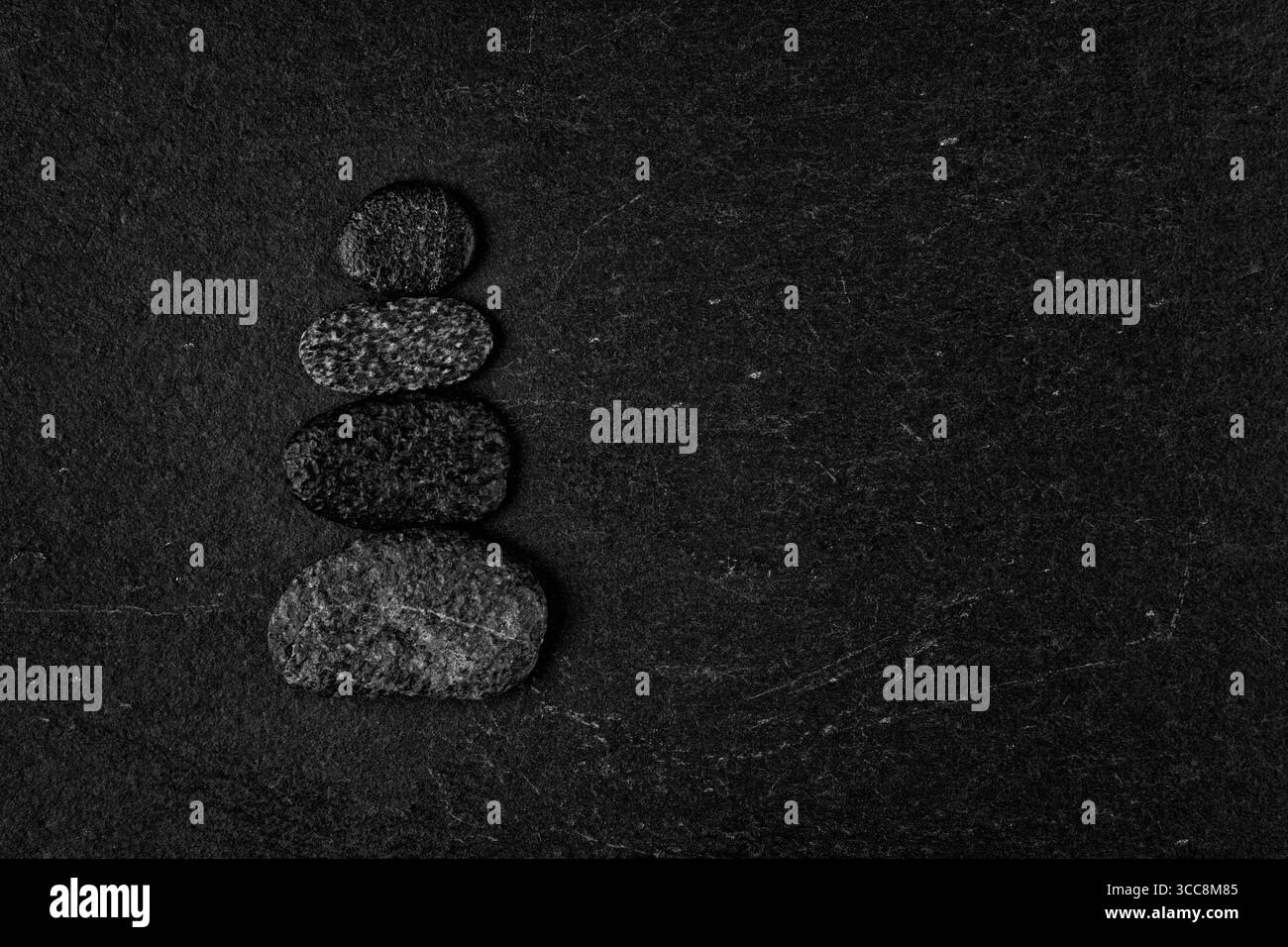 Zen Balancing Pebbles auf schwarzem strukturiertem Hintergrund Stockfoto
