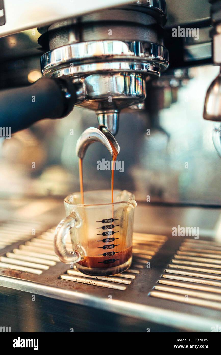 Doppelter Espresso in Messglas eingießen Stockfoto