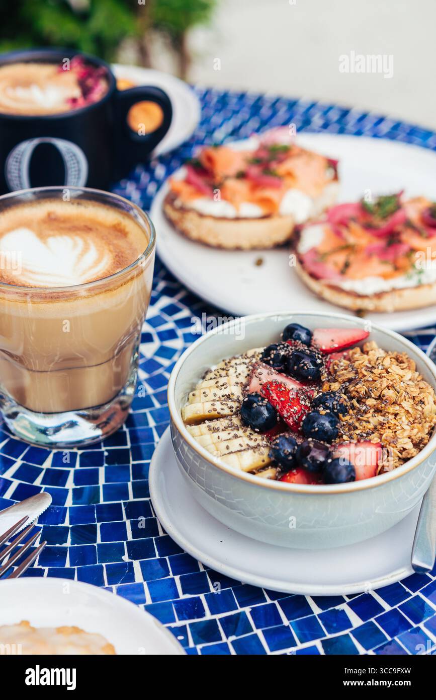 Müslischüssel mit Beeren und Latte-Bagels und geräuchertem Lachs Stockfoto