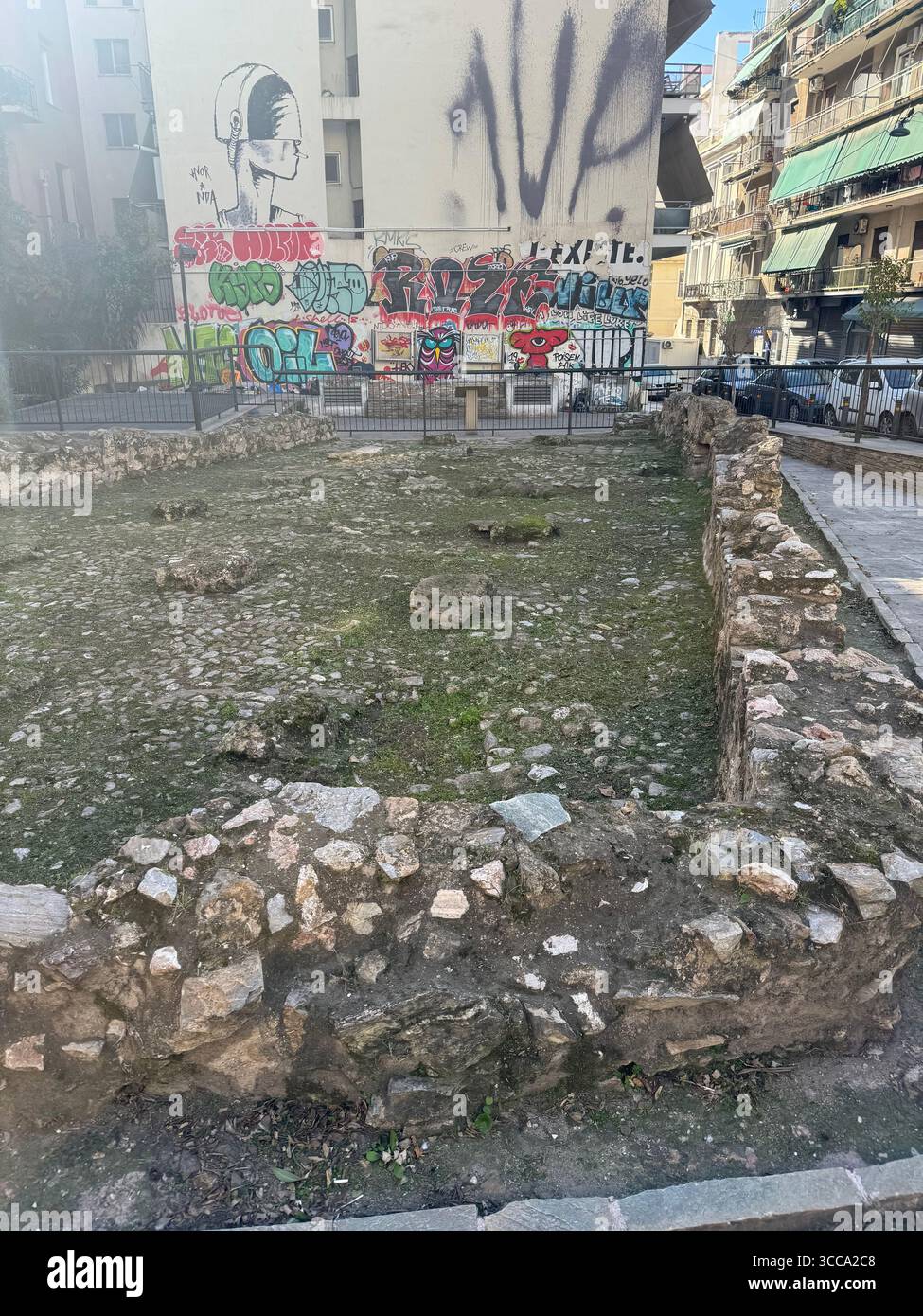 Urbane Straßenszene in Athen, Griechenland, mit antiken Ruinen umgeben von Graffiti-Kunst. Stockfoto