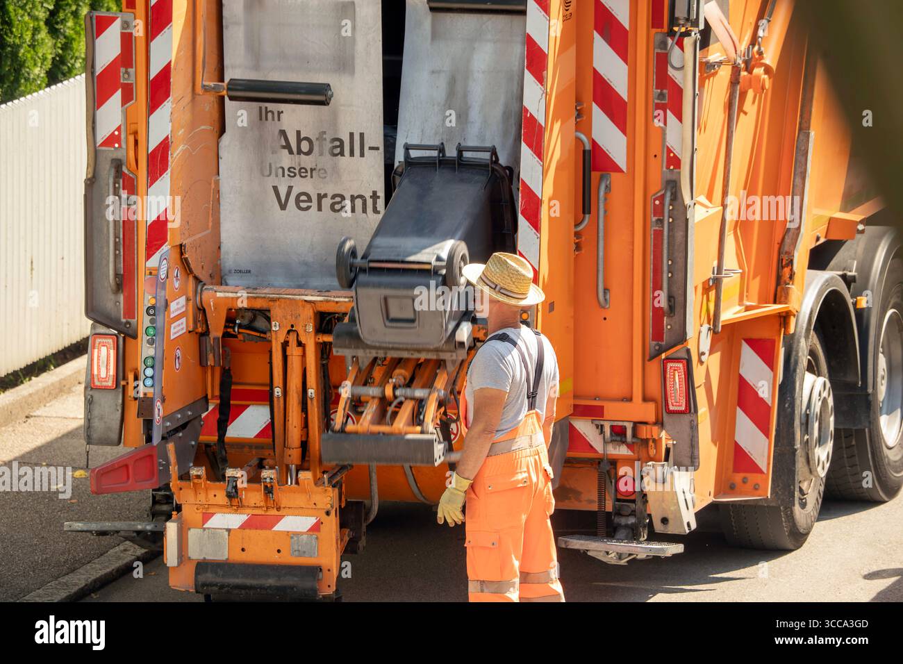 Müllabfuhr leert die Abfalltonnen, München, August 2025 Deutschland, München, August 2025, Mitarbeiter der Münchner Müllabfuhr leeren die grauen Abfalltonnen, wöchentliche Tonnenleerung, in München-Waldperlach immer donnerstags, Abfallwirtschaftsbetrieb München, AWM, größter kommunaler Entsorgungsbetrieb Deutschlands, Müllentsorgung, körperliche Arbeit, Umwelt, Bayern *** Abfallsammlung leert die Mülltonnen, München, August 2025 Deutschland, München, August 2025, Münchner Müllsammler leeren die grauen Mülltonnen, wöchentliche Mülltonnen leeren, in München Waldperlach alle Stockfoto