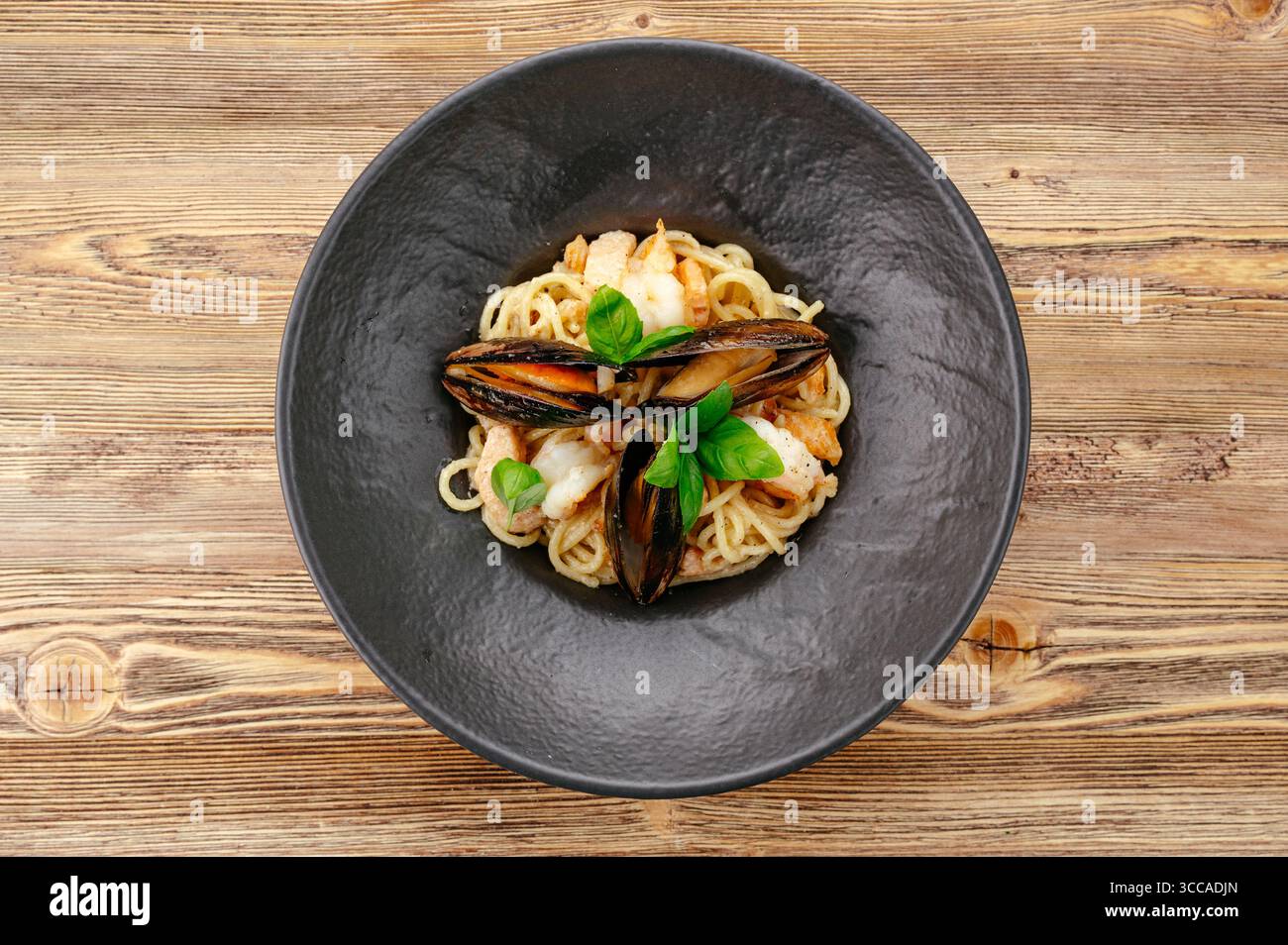 Pasta mit Meeresfrüchten auf einem schwarzen Teller Stockfoto