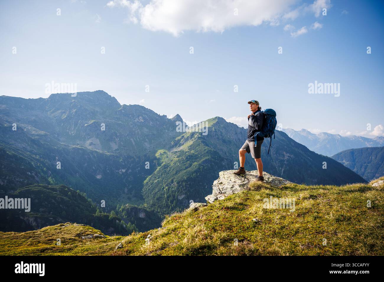 Solo-Backpacker Wandern in den österreichischen Alpen, genießen Sie die Aussicht auf die Bergkette nach dem Aufstieg. Trekking Tour Outdoor Abenteuer Stockfoto