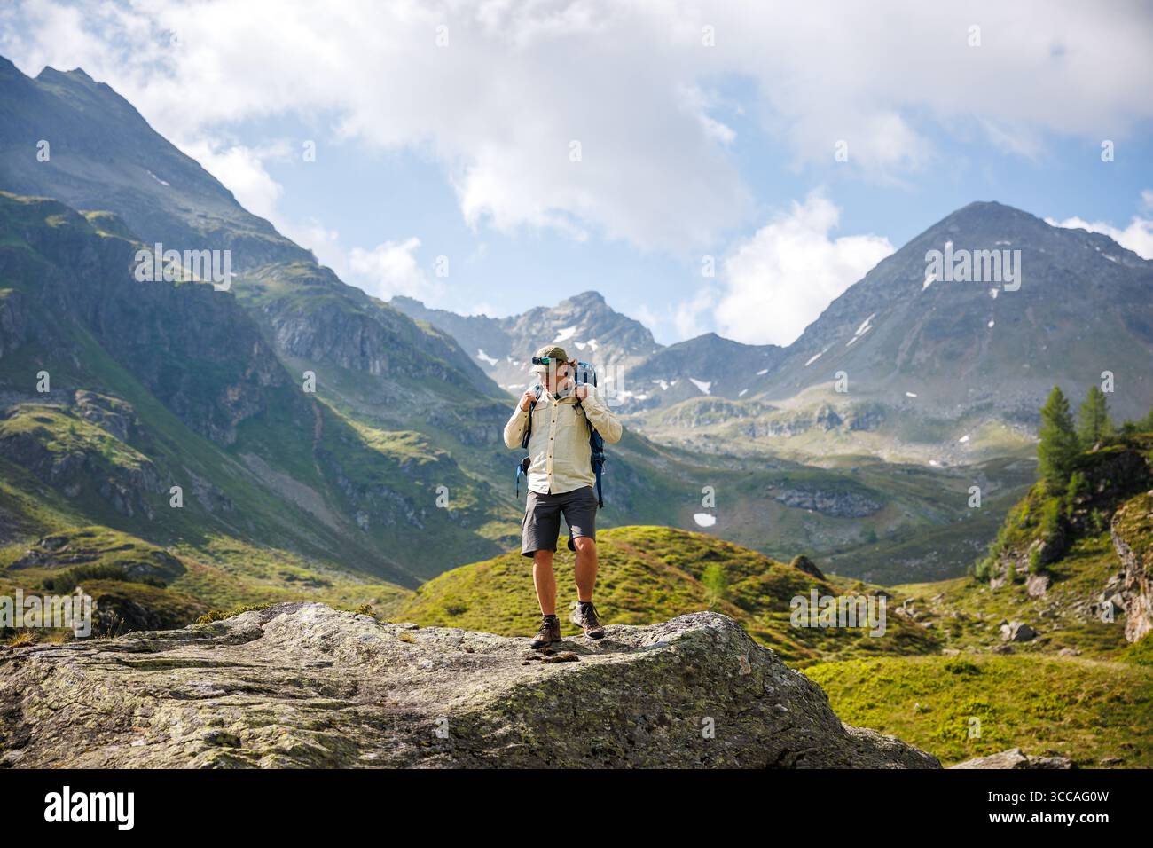 Alleinreisende Wandertouristen mit Rucksack, die abgelegenes Berggelände erkunden. Outdoor-Abenteuer während der Wanderung in den österreichischen Alpen Stockfoto