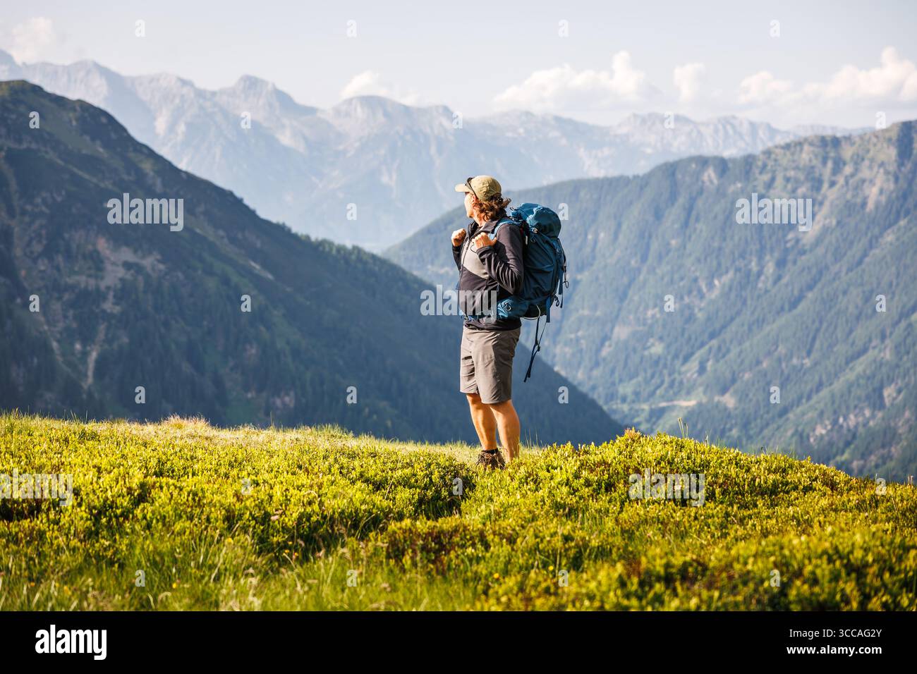 Trekking-Tour. Alleinrucksacktouristen machen bei Wanderungen in den österreichischen Alpen eine Pause und genießen den Blick auf die Dachsteinkette nach dem Aufstieg. Outdoor adve Stockfoto