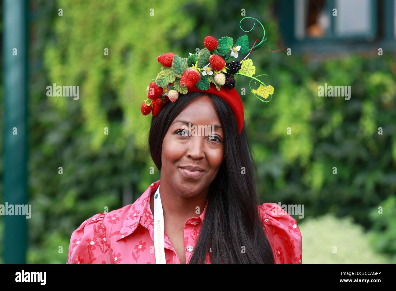 Frau mit Erdbeermütze bei den Wimbledon Champio nships 2025 in London, England, Großbritannien. Stockfoto