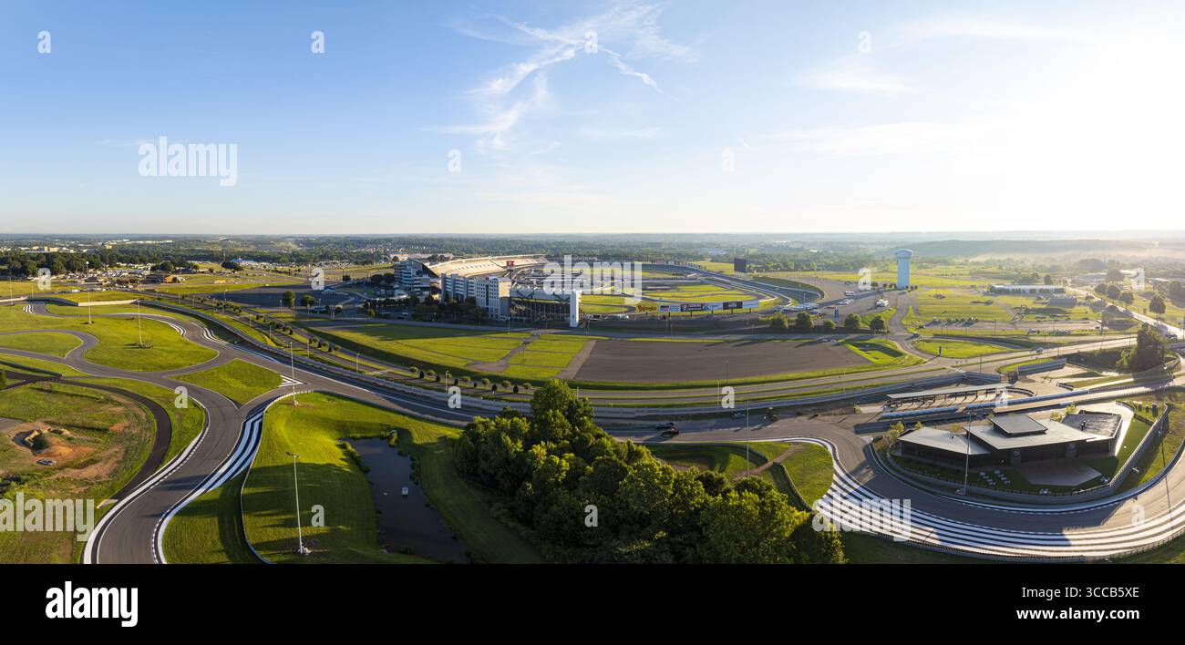 Concord, Vereinigte Staaten - 28. Juli 2025: Aus der Vogelperspektive des Charlotte Motor Speedway, der unter der Morgensonne glänzt, dessen legendäre Strecke ein Asphaltband umgeben von üppigen grünen Landschaften ist. Stockfoto