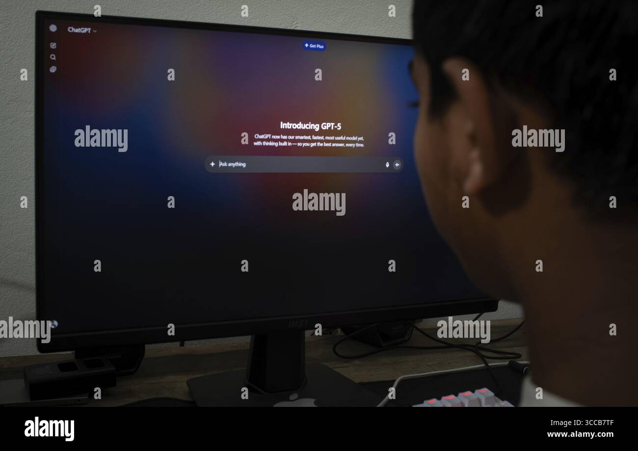 Person, die GPT-5 auf einem Monitor in einem schwach beleuchteten Raum ansieht Stockfoto