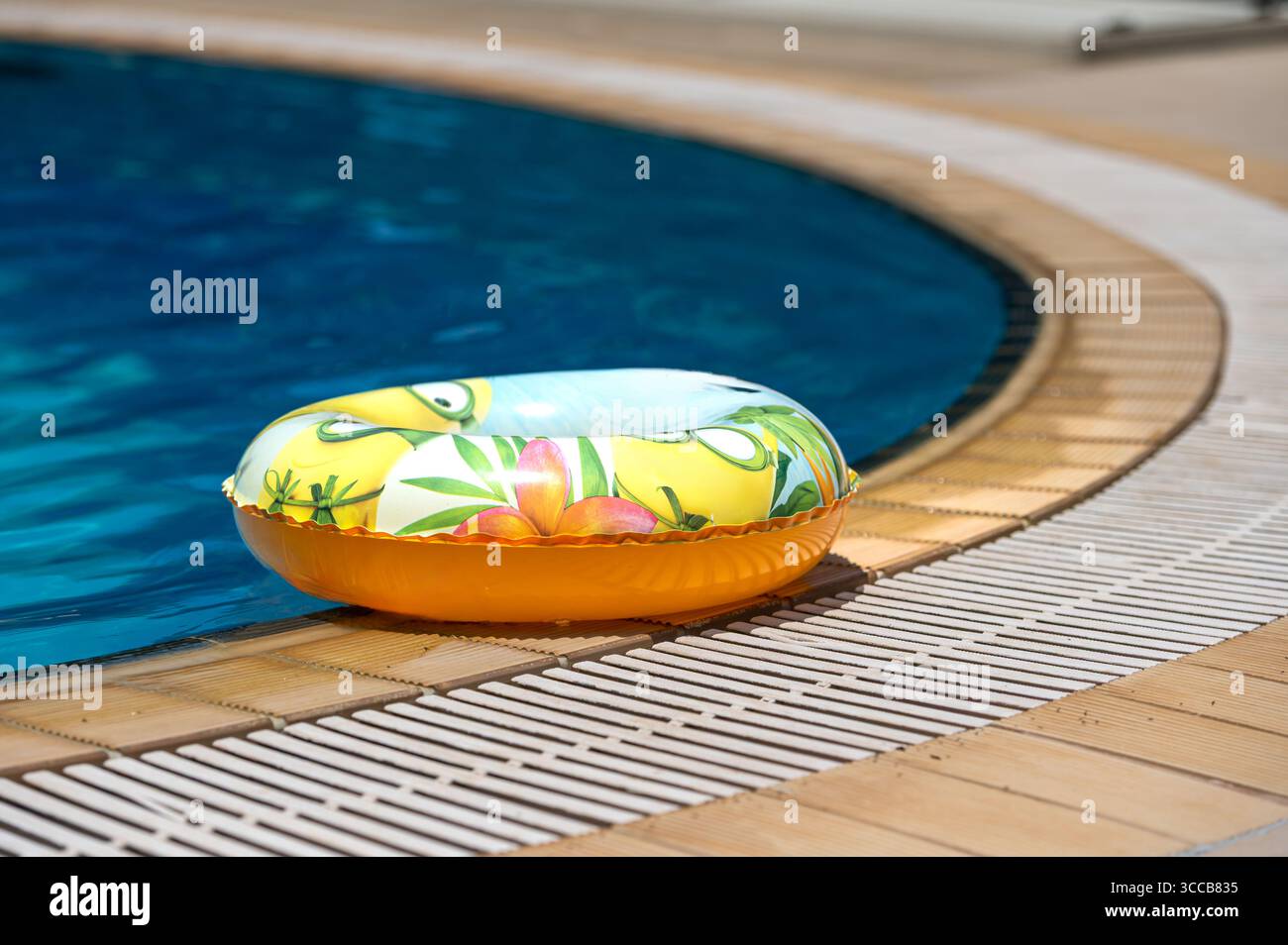 Ein farbenfrohes Schwimmbecken ruht neben kristallklarem Wasser in einer sonnigen Umgebung auf Kreta. Stockfoto